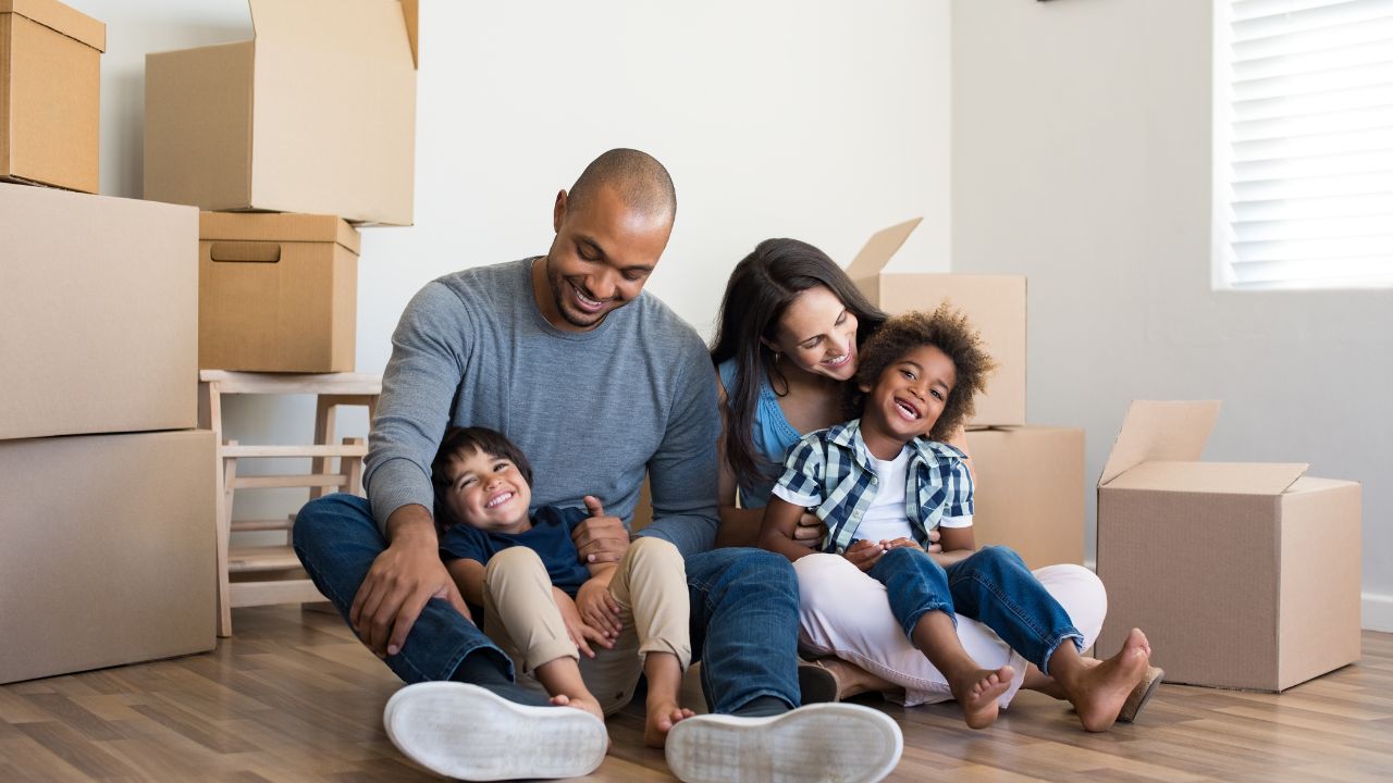 family%20moving%20into%20a%20home%20with%20boxes%20around%20them